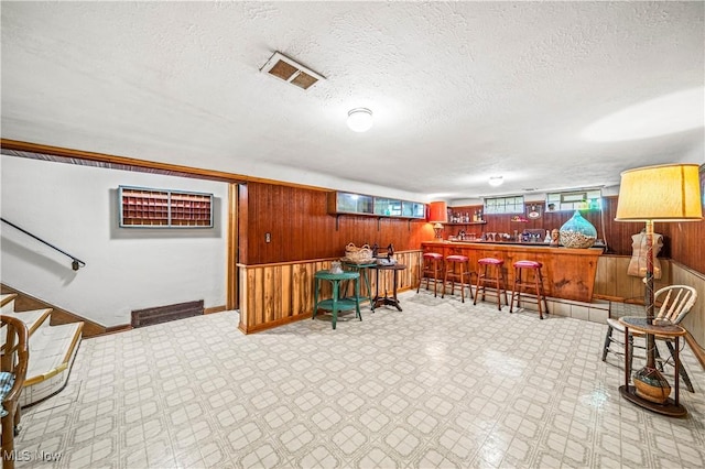 131 E 206th St, Euclid, OH 44123 - office area featuring wooden walls, bar area, a textured ceiling, baseboards, and tile patterned floors