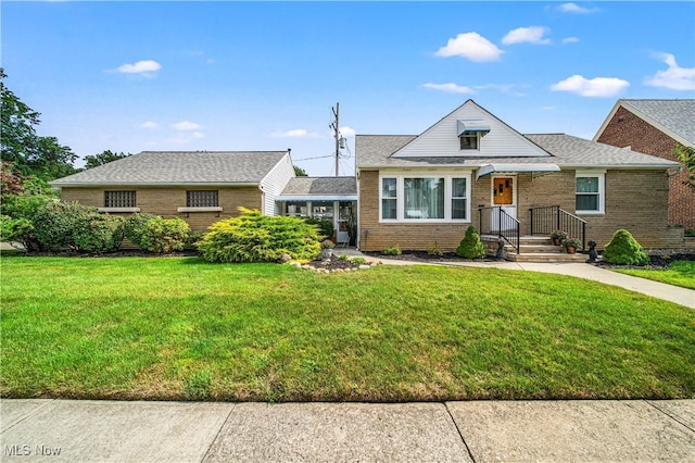 131 E 206th St, Euclid, OH 44123 - bungalow with brick siding, a front lawn, and roof with shingles