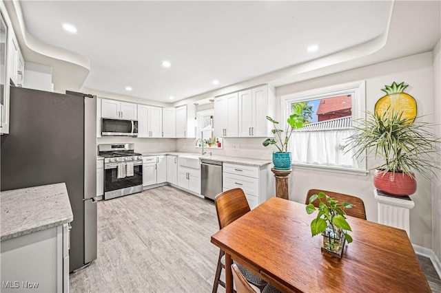 131 E 206th St, Euclid, OH 44123 - kitchen featuring appliances with stainless steel finishes, a sink, white cabinets, light wood-type flooring, and recessed lighting