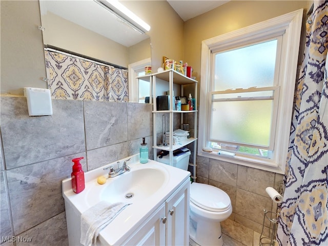 3882 Wallingford Rd, South Euclid, OH 44121 - bathroom featuring tile walls, plenty of natural light, toilet, vanity, and a shower with shower curtain