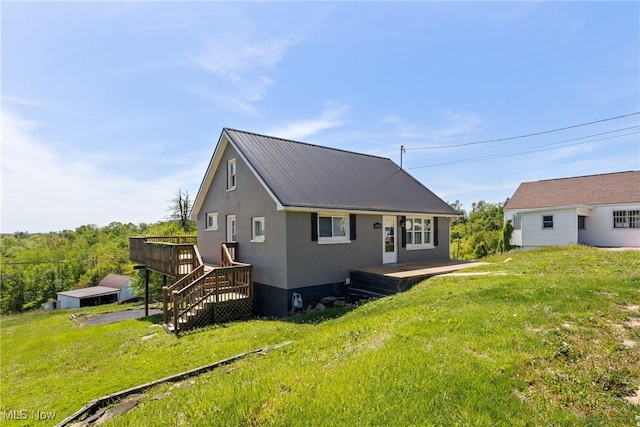 60620 Main St, Jacobsburg, OH 43933 - back of property with a deck, a lawn, and metal roof
