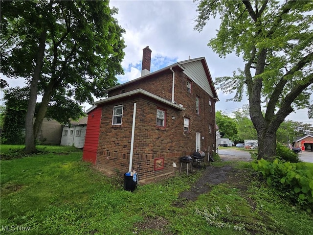 958 E Wilbeth Rd, Akron, OH 44306 - view of side of property with a chimney, brick siding, and a yard