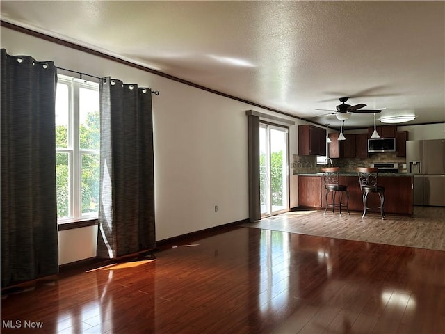 95 Cheyenne Dr, Girard, OH 44420 - unfurnished living room with a ceiling fan, healthy amount of natural light, wood finished floors, ornamental molding, and a textured ceiling