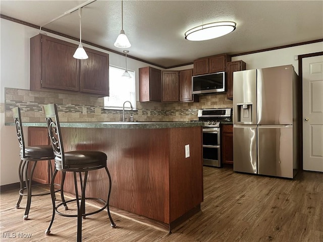 95 Cheyenne Dr, Girard, OH 44420 - kitchen featuring stainless steel appliances, wood finished floors, tasteful backsplash, dark countertops, and crown molding