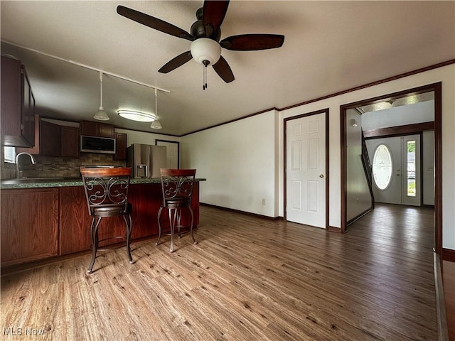 95 Cheyenne Dr, Girard, OH 44420 - kitchen with stainless steel appliances, a peninsula, wood finished floors, dark countertops, and ceiling fan
