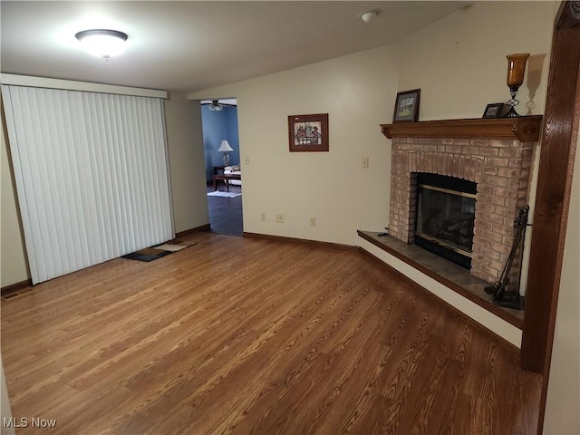 5747 E Clinton St, Albany, OH 45710 - unfurnished living room with wood finished floors, a fireplace, baseboards, and a ceiling fan