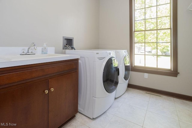 681 Tamarac Trl, Wadsworth, OH 44281 - laundry area featuring cabinet space, washer and dryer, light tile patterned floors, and baseboards