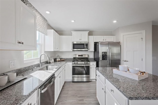 149 Hidden Village Dr Unit S/L 152, Perry, OH 44081 - kitchen featuring appliances with stainless steel finishes, a sink, light wood-style floors, white cabinetry, and stone countertops
