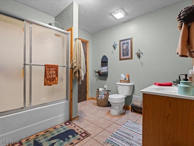 10664 W Little Kanawha Hwy, Mount Zion, WV 26151 - bathroom with bath / shower combo with glass door, toilet, vanity, tile patterned flooring, and a textured ceiling