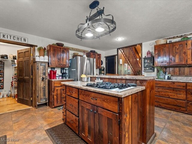 10664 W Little Kanawha Hwy, Mount Zion, WV 26151 - kitchen with freestanding refrigerator, a center island, light countertops, gas cooktop, and a textured ceiling