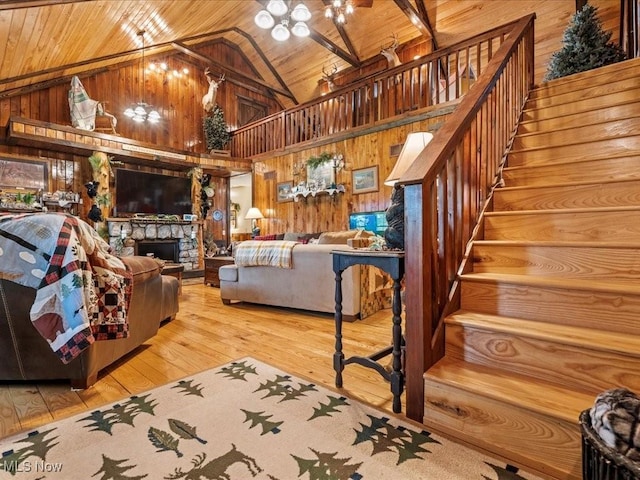10664 W Little Kanawha Hwy, Mount Zion, WV 26151 - living room featuring wood walls, high vaulted ceiling, a chandelier, wood ceiling, and stairs