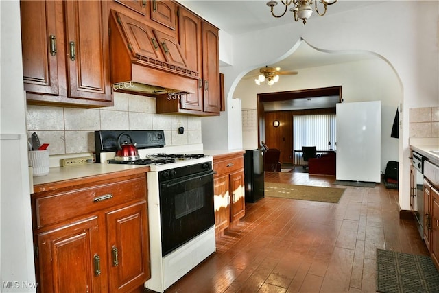 2816 E Market St, Warren, OH 44483 - kitchen with gas stove, custom range hood, arched walkways, light countertops, and tasteful backsplash