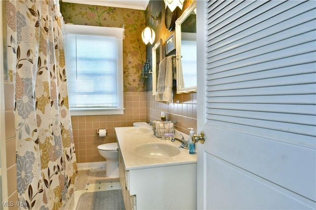 2816 E Market St, Warren, OH 44483 - bathroom featuring wallpapered walls, toilet, wainscoting, tile walls, and vanity