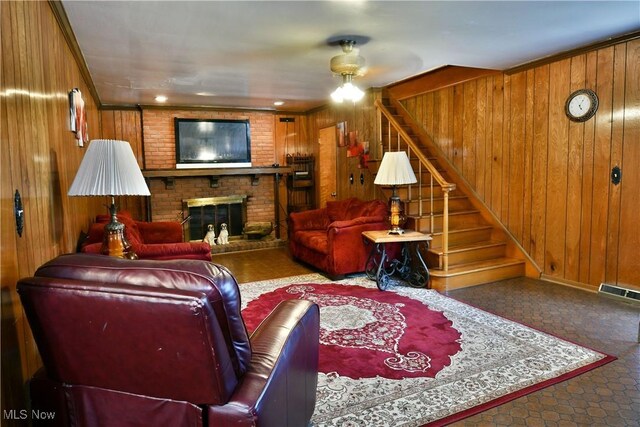 2816 E Market St, Warren, OH 44483 - living room featuring wooden walls, stairs, a brick fireplace, and a ceiling fan