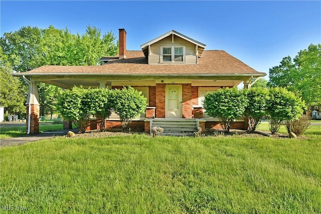 2816 E Market St, Warren, OH 44483 - view of front of house with a chimney, a front lawn, brick siding, and a carport