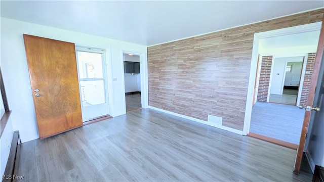 3205 State Rd, Ashtabula, OH 44004 - unfurnished room featuring wood finished floors, baseboards, baseboard heating, and an accent wall