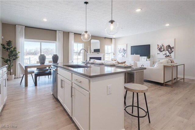 4367 Main St, Perry, OH 44081 - kitchen with a sink, stainless steel dishwasher, a textured ceiling, a fireplace, and a breakfast bar area