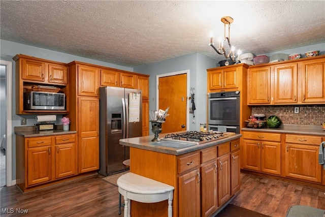 2993 Harris Hwy, Washington, WV 26181 - kitchen with appliances with stainless steel finishes, dark wood finished floors, a textured ceiling, and brown cabinetry