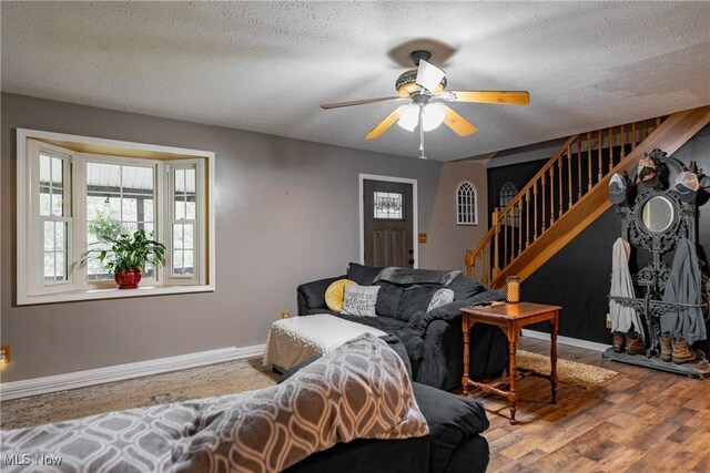 2993 Harris Hwy, Washington, WV 26181 - living room with stairs, wood finished floors, ceiling fan, a textured ceiling, and baseboards