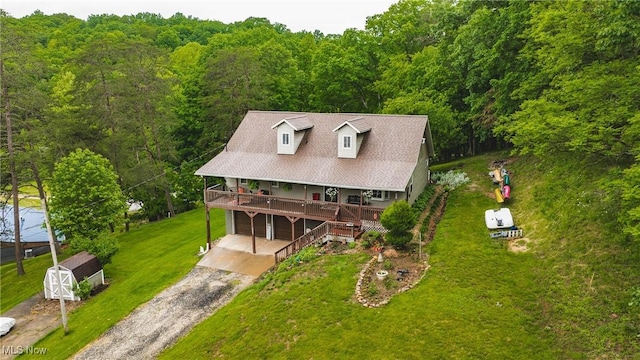 2993 Harris Hwy, Washington, WV 26181 - view of front of home with driveway, a front yard, a forest view, a deck, and an attached garage