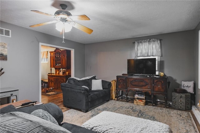 2993 Harris Hwy, Washington, WV 26181 - living room with wood finished floors, a ceiling fan, and a textured ceiling