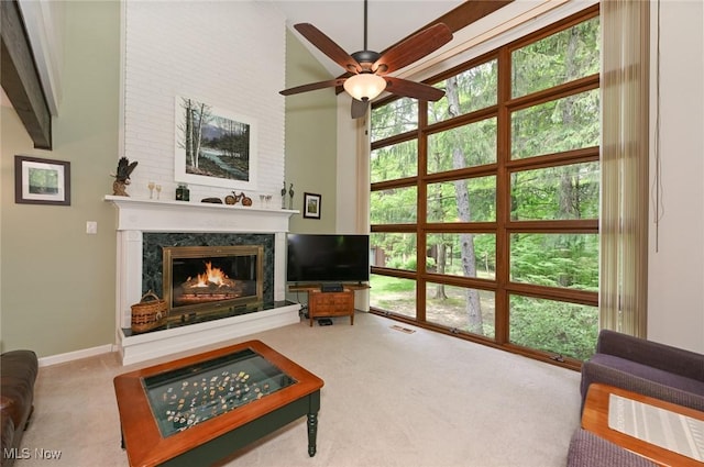 947 Trimble Pl, Sagamore Hills, OH 44067 - living room with carpet flooring, a premium fireplace, a ceiling fan, a high ceiling, and baseboards