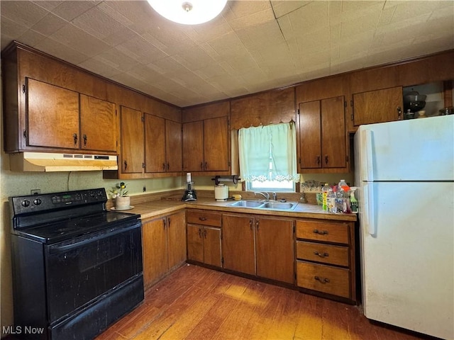 202 E Spring St, Bethesda, OH 43719 - kitchen with freestanding refrigerator, black range with electric cooktop, under cabinet range hood, and brown cabinetry