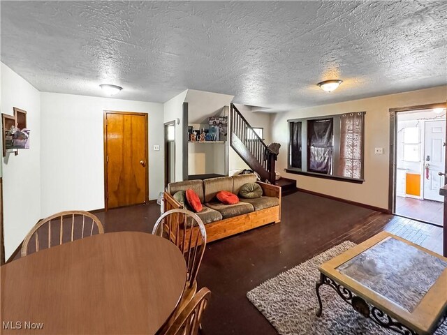 14014 Sylvia Ave, Cleveland, OH 44110 - living room featuring stairway, a textured ceiling, and baseboards