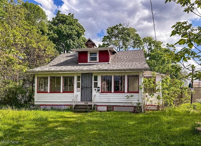 14014 Sylvia Ave, Cleveland, OH 44110 - bungalow-style house with a front lawn, a shingled roof, and entry steps