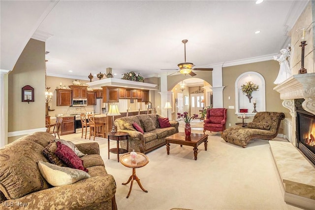 29 Amber Way, Norwalk, OH 44857 - living area featuring decorative columns, a glass covered fireplace, arched walkways, ceiling fan, and crown molding