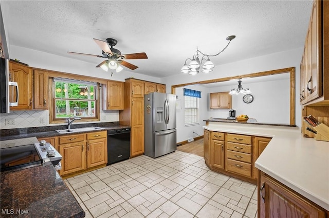 27539 Linwood Cir, North Olmsted, OH 44070 - kitchen featuring appliances with stainless steel finishes, a sink, a chandelier, a ceiling fan, and brown cabinetry