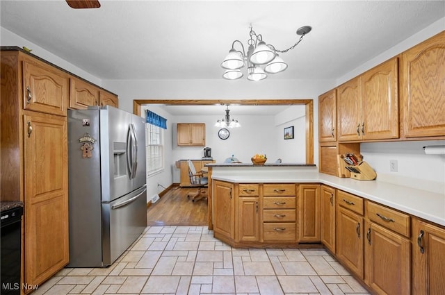 27539 Linwood Cir, North Olmsted, OH 44070 - kitchen with stainless steel fridge with ice dispenser, a chandelier, a peninsula, light countertops, and brown cabinetry