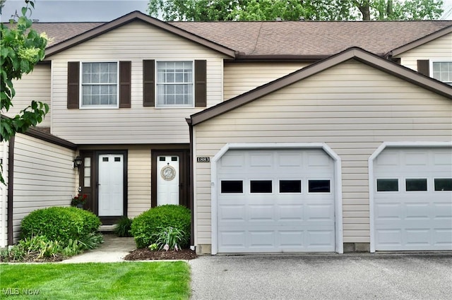 1883 Ridge Meadow Ct, Twinsburg, OH 44087 - townhome / multi-family property with driveway, a garage, and a shingled roof