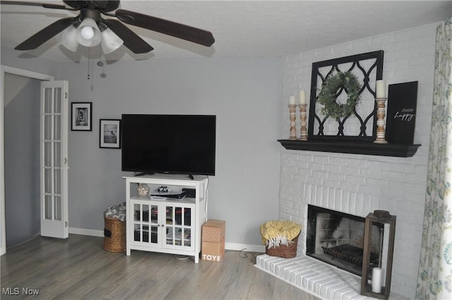 1883 Ridge Meadow Ct, Twinsburg, OH 44087 - living room featuring ceiling fan, wood finished floors, a fireplace, baseboards, and a textured ceiling