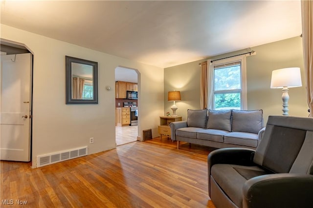 3796 Sweitzer St NW, Uniontown, OH 44685 - living room featuring arched walkways, wood finished floors, and baseboards