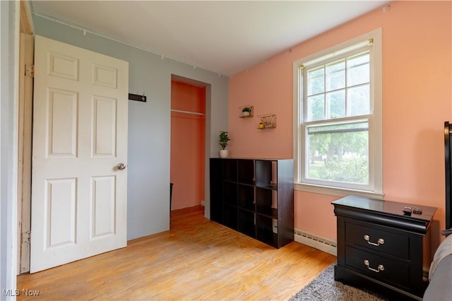 3796 Sweitzer St NW, Uniontown, OH 44685 - bedroom featuring baseboard heating, light wood-style flooring, multiple windows, and a closet