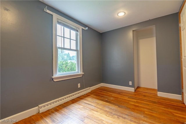 3796 Sweitzer St NW, Uniontown, OH 44685 - unfurnished room featuring a baseboard radiator, plenty of natural light, light wood finished floors, and baseboards