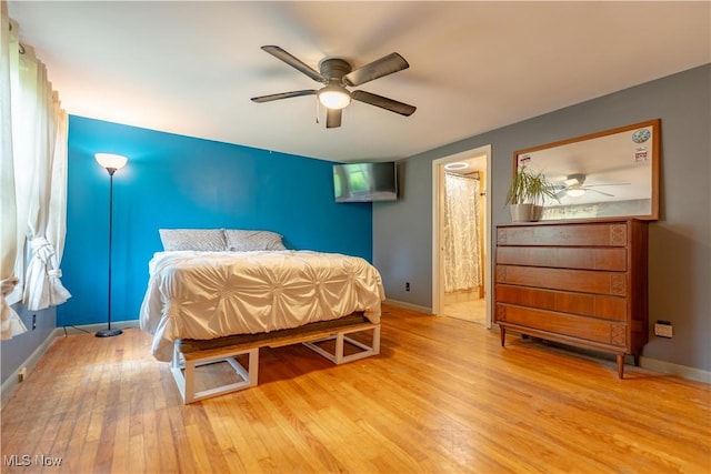 3796 Sweitzer St NW, Uniontown, OH 44685 - bedroom with wood finished floors, baseboards, a ceiling fan, and connected bathroom
