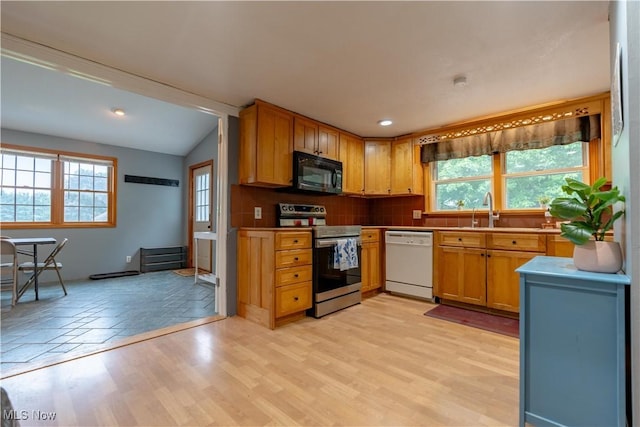 3796 Sweitzer St NW, Uniontown, OH 44685 - kitchen with white dishwasher, black microwave, stainless steel electric range, plenty of natural light, and vaulted ceiling