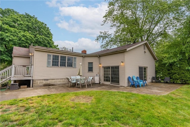 3796 Sweitzer St NW, Uniontown, OH 44685 - rear view of house featuring a patio, a lawn, and central AC
