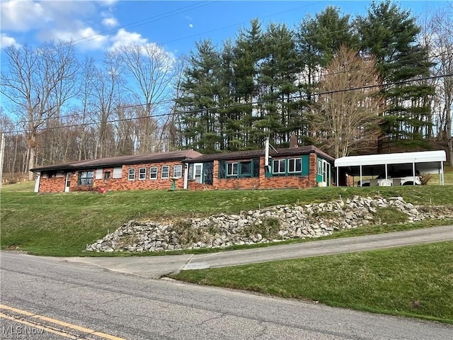 20022 County Road 6, Coshocton, OH 43812 - ranch-style house featuring a chimney, a front lawn, and a carport