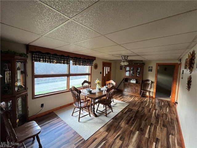 20022 County Road 6, Coshocton, OH 43812 - dining room with dark wood finished floors, a paneled ceiling, a ceiling fan, and baseboards