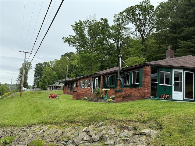 20022 County Road 6, Coshocton, OH 43812 - view of side of home with a lawn, a chimney, and brick siding
