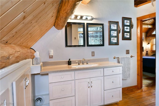 18102 Owen Rd, Middlefield, OH 44062 - bathroom featuring vanity, hardwood / wood-style flooring, lofted ceiling, and ensuite bath