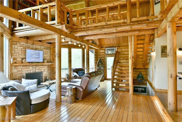 18102 Owen Rd, Middlefield, OH 44062 - living area with wood-type flooring, a fireplace, log walls, and wood ceiling with exposed beams