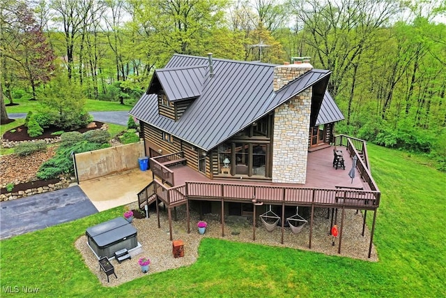 18102 Owen Rd, Middlefield, OH 44062 - back of property with a wooden deck, a standing seam roof, a chimney, and a yard