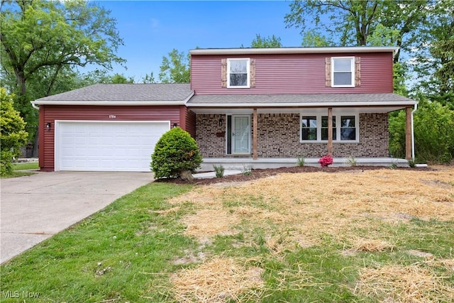 1704 Emerald Dr, Lorain, OH 44053 - traditional home with an attached garage, concrete driveway, covered porch, brick siding, and a front lawn