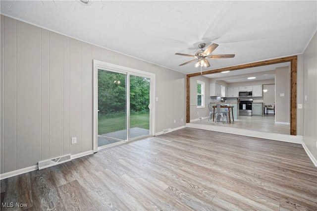 1704 Emerald Dr, Lorain, OH 44053 - unfurnished living room featuring a ceiling fan, light wood finished floors, and baseboards