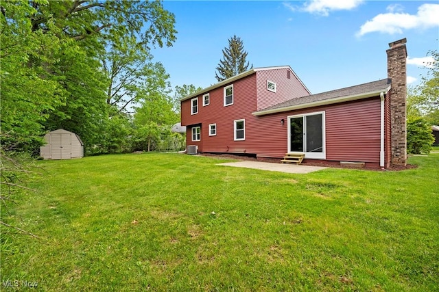 1704 Emerald Dr, Lorain, OH 44053 - back of property with a chimney, a patio, a lawn, central AC unit, and entry steps