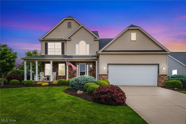 1487 Barrymore Ln, Wadsworth, OH 44281 - view of front of house with concrete driveway, covered porch, a lawn, stone siding, and a garage